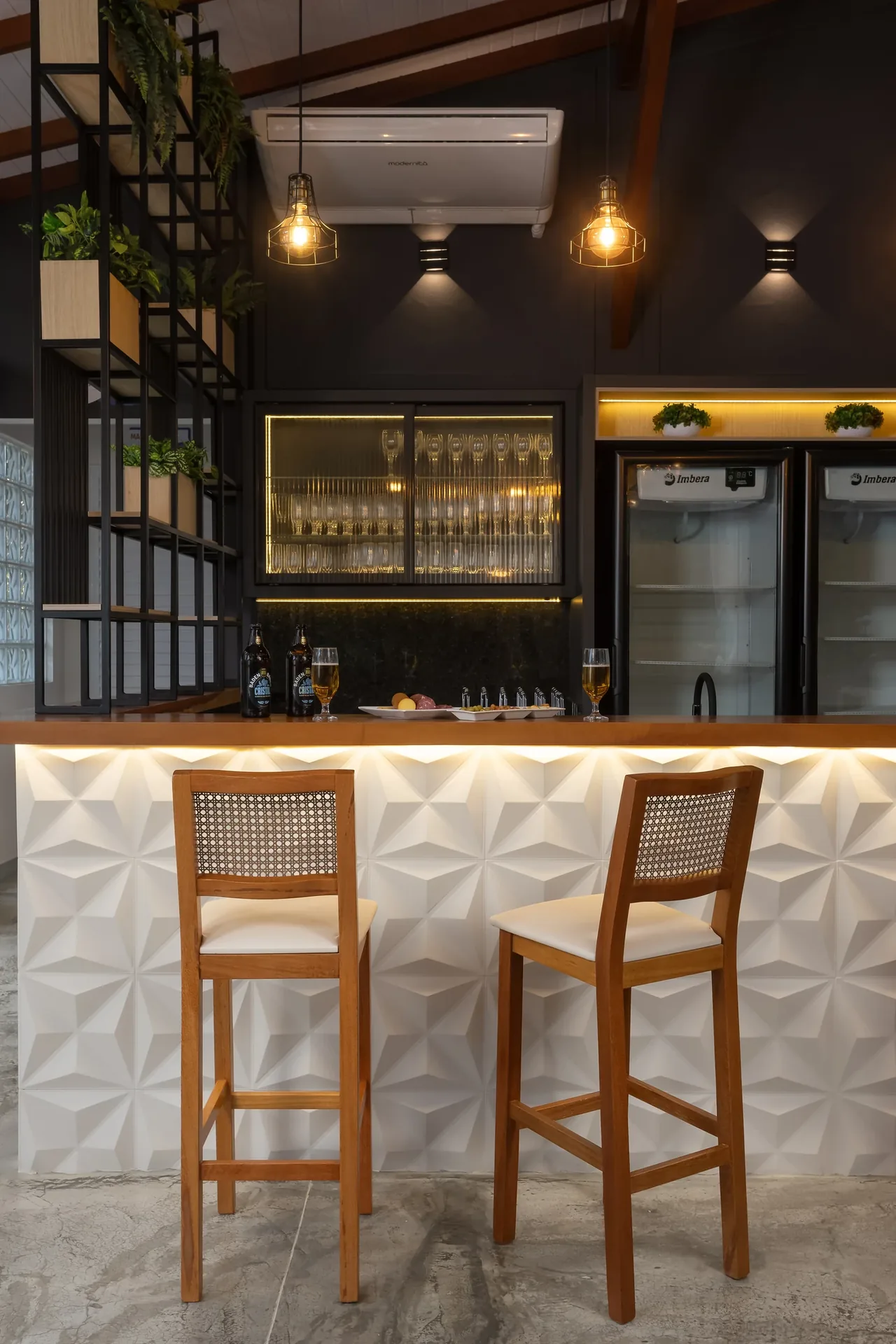 Dos taburetes de madera con respaldos de rejilla junto a la barra de un bar